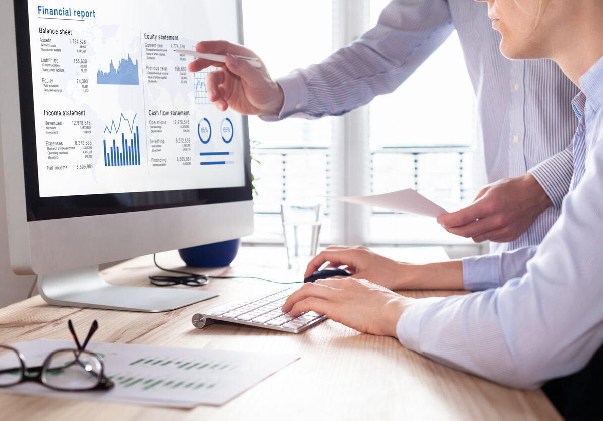 Team of consulting auditors auditing the financial report data of the company (balance sheet, income statement) on computer screen with business charts, fintech